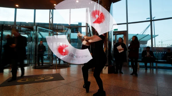 Woman twirling Pendulum banners at the Convention Centre Dublin for Pendulum Summit on contact us page